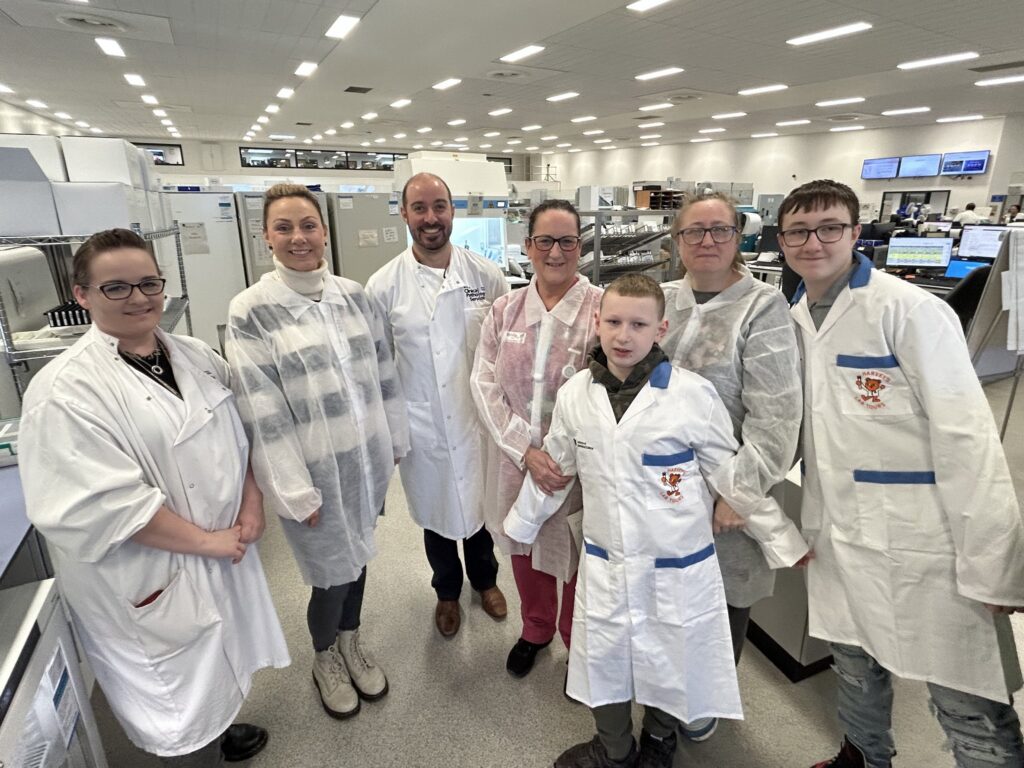 A group of staff and visitors had a group photo in the Pathology labs.