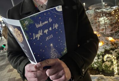 A close up photo of hands holding an order of service booklet