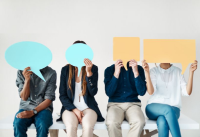 People sat on a bench holding up speech bubbles.