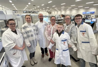 A group of staff and visitors had a group photo in the Pathology labs.